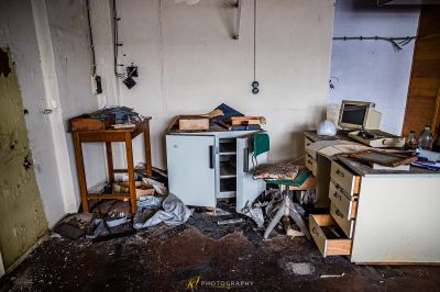 Eine chaotische Küche mit Kühlschrank und viel Müll