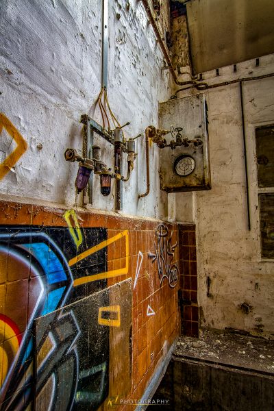 Ein Graffiti überdachtes Badezimmer mit Toilette und Waschbecken