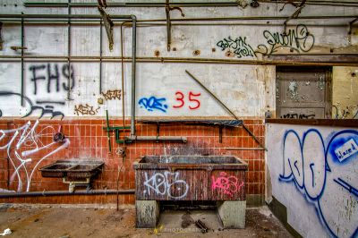 Ein schmutziges Badezimmer mit Graffiti an den Wänden