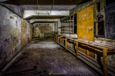 Ein Zimmer mit einem Bündel von Fenstern und einer Wand mit Graffiti