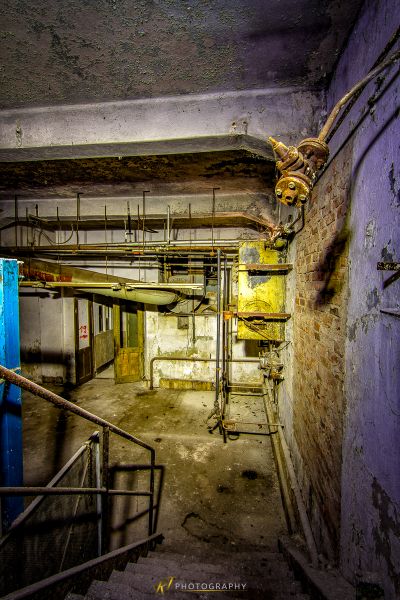 Ein Zimmer mit einem Haufen Pfeifen und einer blauen Tür