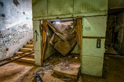 Ein Zimmer mit einer kaputten Tür und einer Wand mit Graffiti