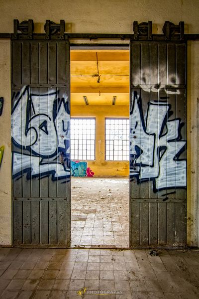 Ein Raum mit einer Tür und Graffiti an den Wänden