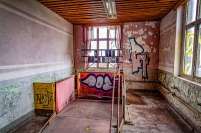 Ein Raum mit Graffiti an den Wänden und einer Leiter