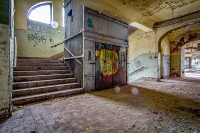 Ein Raum mit einer Treppe und Graffiti an den Wänden