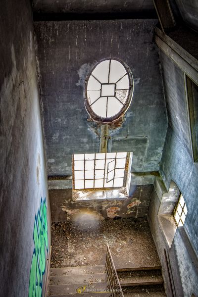 Eine Uhr hängt an der Decke eines verlassenen Gebäudes