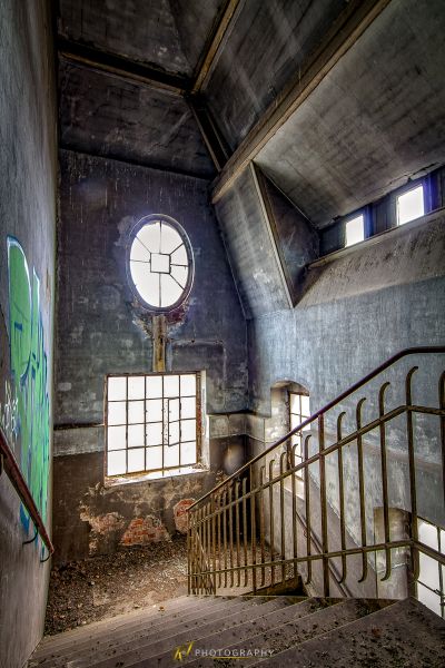 Eine Treppe in einem verlassenen Gebäude mit einer Uhr