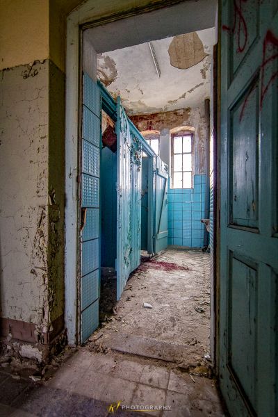 Ein Zimmer mit blauen Türen und schälenden Wänden