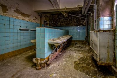 Ein schmutziges Badezimmer mit Waschbecken und Spiegel