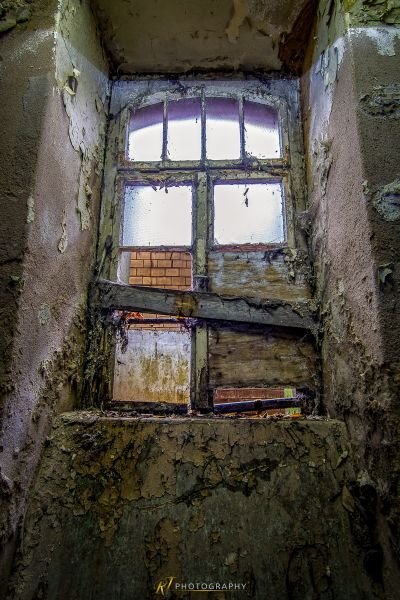 Ein Fenster in einem alten Gebäude mit schälender Farbe
