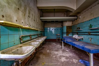 Ein schmutziges Badezimmer mit zwei Waschbecken und einer Bank