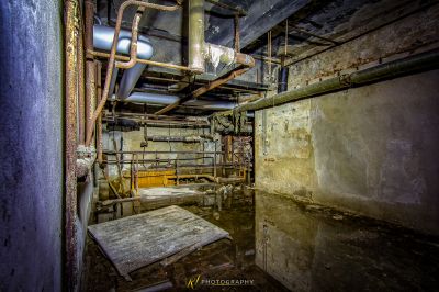 Ein Zimmer mit einer großen Pfeife und einem Holzboden