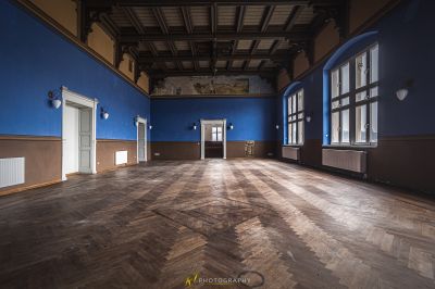 Ein Zimmer mit einem Holzboden und blauen Wänden