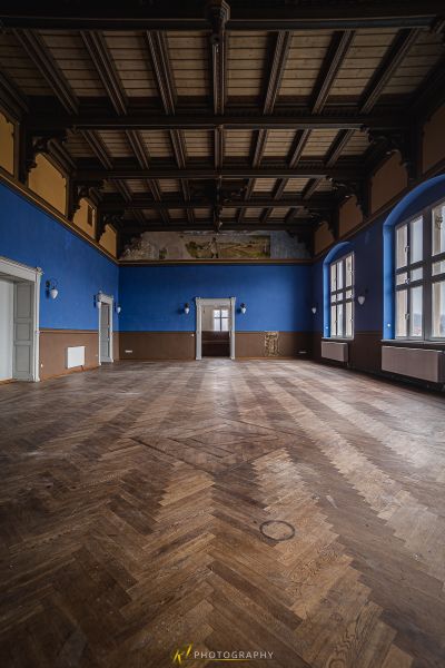 Ein Zimmer mit einem Holzboden und einer blauen Wand