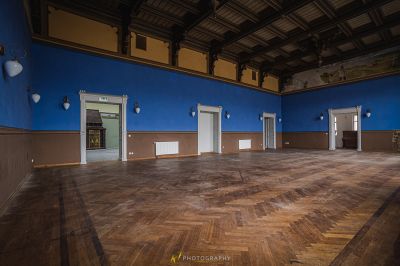 Ein Zimmer mit einem Holzboden und blauen Wänden