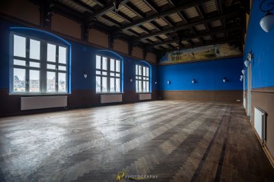 Ein Zimmer mit einem großen Holzboden und einer blauen Wand