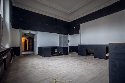 Ein Zimmer mit einem Holzboden und einer schwarzen Wand