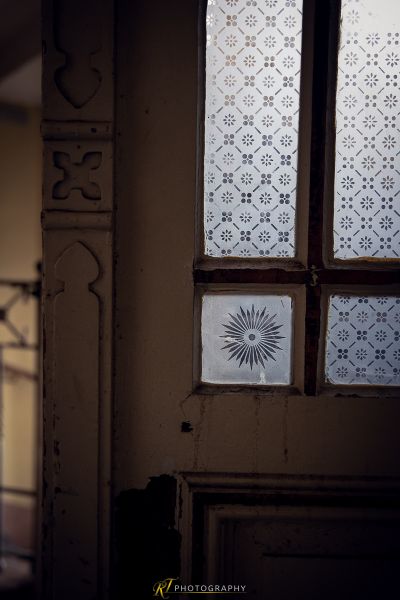 Eine Tür mit einem Fenster und einer tapezierten Wand