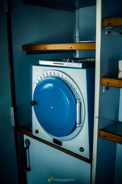 Eine blau-weiße Waschmaschine, die in einem Raum sitzt