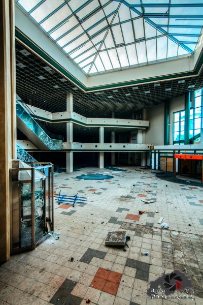 Ein großer Raum mit einer zerbrochenen Decke und einer zerbrochenen Glastür