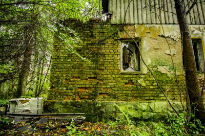 Ein verfallenes Gebäude mit einem zerbrochenen Fenster und einer kaputten Tür