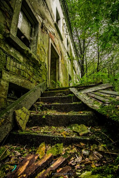 Ein sehr altes Gebäude mit viel Moos wächst auf dem Boden