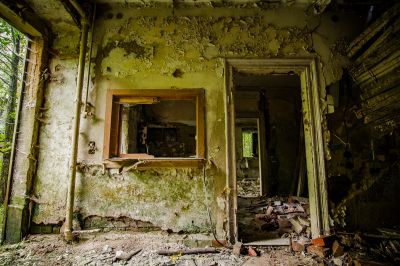 Ein Zimmer mit einem zerbrochenen Fenster und einer Wand