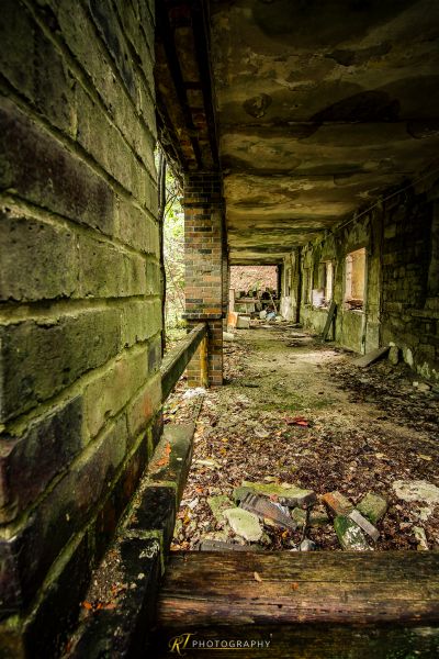 Ein langes, schmutziges, herunterlaufendes Gebäude mit einem Haufen Blätter auf dem Boden