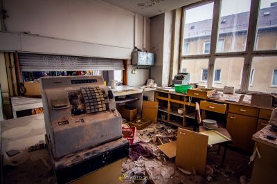 Ein chaotisches Büro mit einem kaputten Kühlschrank und viel Müll