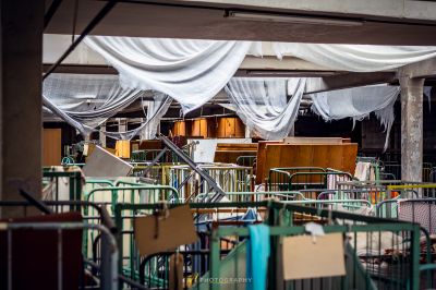 Ein Zimmer mit vielen Tischen und Stühlen mit weißem Tuch bedeckt