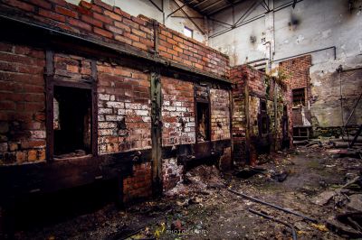 Ein Zimmer mit einer Ziegelwand und einer kaputten Tür