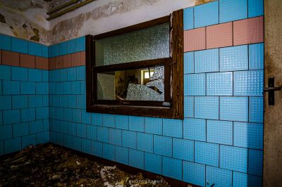 Ein Badezimmer mit einem zerbrochenen Fenster und einem zerbrochenen Spiegel