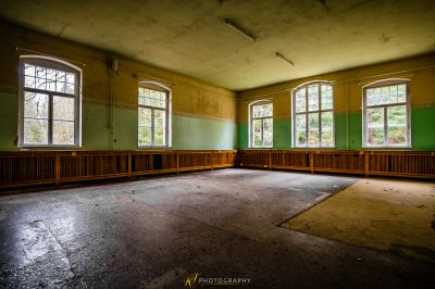 Ein Zimmer mit vielen Fenstern und viel Holz