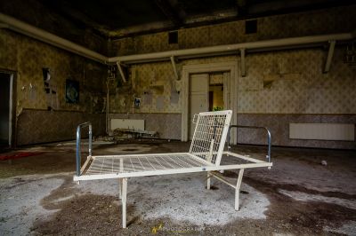 Ein Bett in einem Zimmer mit einer tapezierten Wand