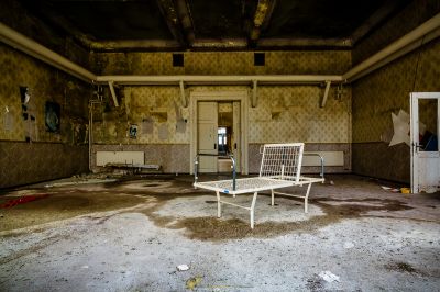 Ein Zimmer mit Stuhl und Kühlschrank