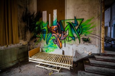 Ein Bett in einem Zimmer mit Graffiti an der Wand