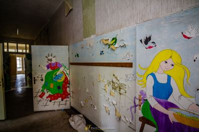 Eine Wand mit einem Gemälde von einem Mädchen und Vögeln