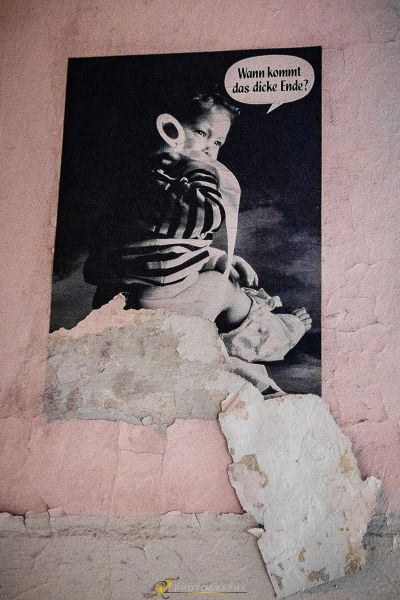 Ein Bild von einer Frau, die an einer Wand sitzt