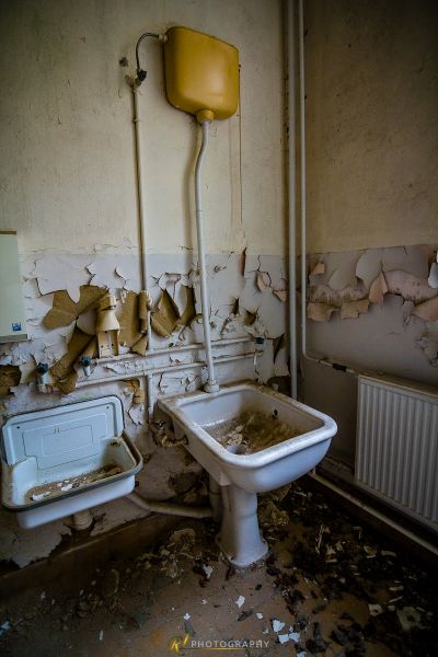 Ein Badezimmer mit einer kaputten Toilette und einem kaputten Waschbecken