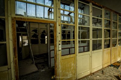 Ein Zimmer mit einem kaputten Fenster und einer kaputten Tür