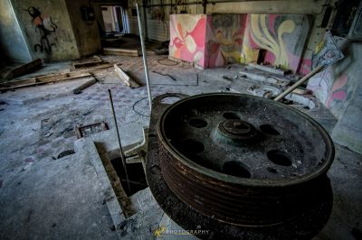 Ein schmutziger Raum mit einem gebrochenen Rad und Graffiti an den Wänden