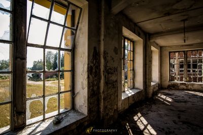 Ein Zimmer mit Fenster und Blick auf ein Feld