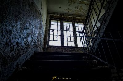 Eine Treppe mit einem zerbrochenen Fenster und einer kaputten Tür