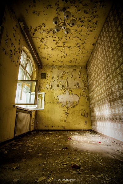 Ein Zimmer mit einem Deckenventilator und einer tapezierten Wand