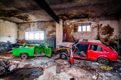 Ein rotes Auto ist in einem schmutzigen Raum geparkt