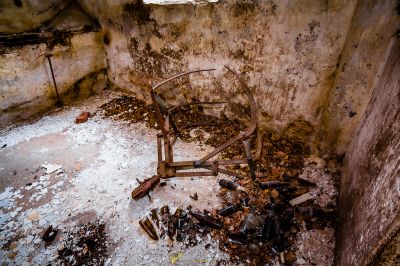 Ein Stuhl in einem schmutzigen Raum mit viel Müll