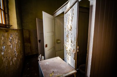 Ein schmutziges Badezimmer mit einer Tür und einem Waschbecken