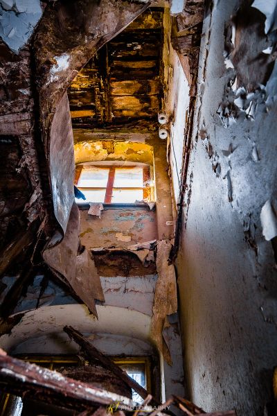 Ein Zimmer mit einer zerbrochenen Decke und einem zerbrochenen Fenster