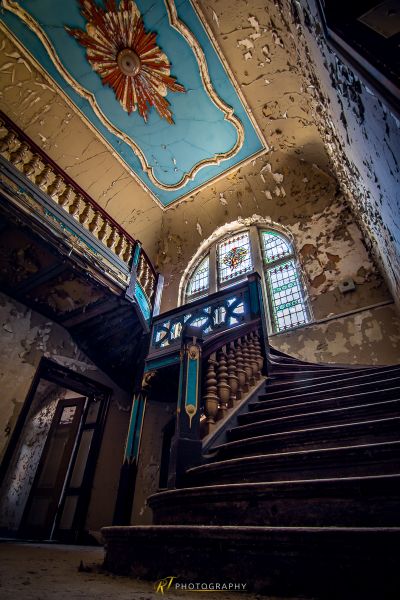 Eine Treppe in einem alten Gebäude mit einer Uhr
