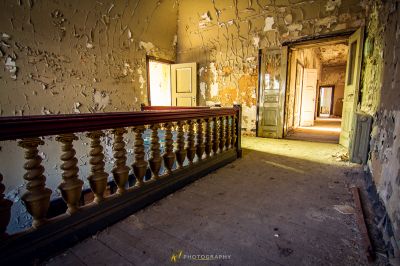 Ein Zimmer mit einem hölzernen Geländer und einer Tür